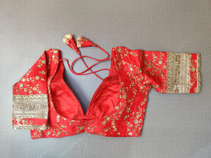 Buy Red and gold-coloured embroidered saree blouse has a deep neck, floral and back open with hook online in USA. Pair this fancy designer sari blouse crafted with beautiful golden lace border, dori ties with ethnic sari, designer saree blouses online, sari blouses from Pure Elegance Indian fashion store in USA.- Back.