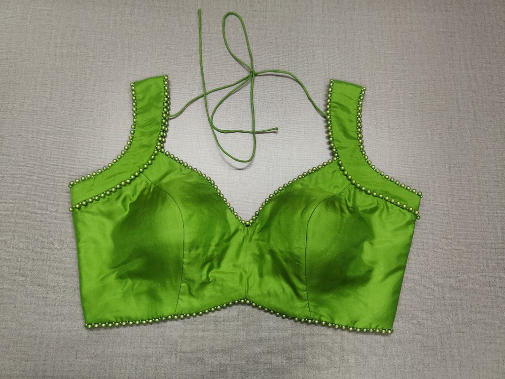 Shop Classic V-Neckline sleeveless blouse in lime green Colour with a stylized Deep "U" back. It has a tie at the back for that perfect fitting. Complement your pick with a classy saree or an aesthetic lehenga. Shop designer sari blouse from Pure Elegance Indian fashion store in USA where each of these items are handmade by passionate creators & might slightly vary from one another.-Front view.