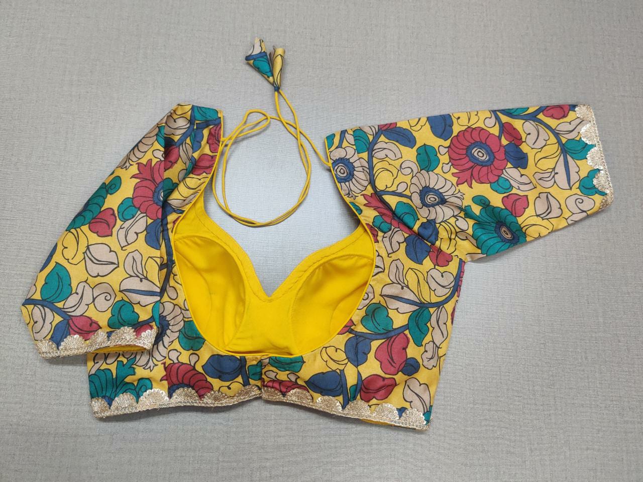 Buy beautiful yellow Kalamkari saree blouse online in USA with golden lace. Elevate your Indian ethnic sarees with beautiful readymade sari blouses, embroidered saree blouses, Banarasi saree blouse, designer sari blouses, choli-cut blouses from Pure Elegance Indian fashion store in USA.-back