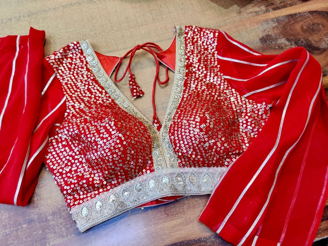 Buy stunning red sequin embroidered designer saree blouse online in USA. Elevate your ethnic saree style with a tasteful collection of designer saree blouses, embroidered sari blouses, Banarasi blouses, silk saree blouses from Pure Elegance Indian clothing store in USA.-front
