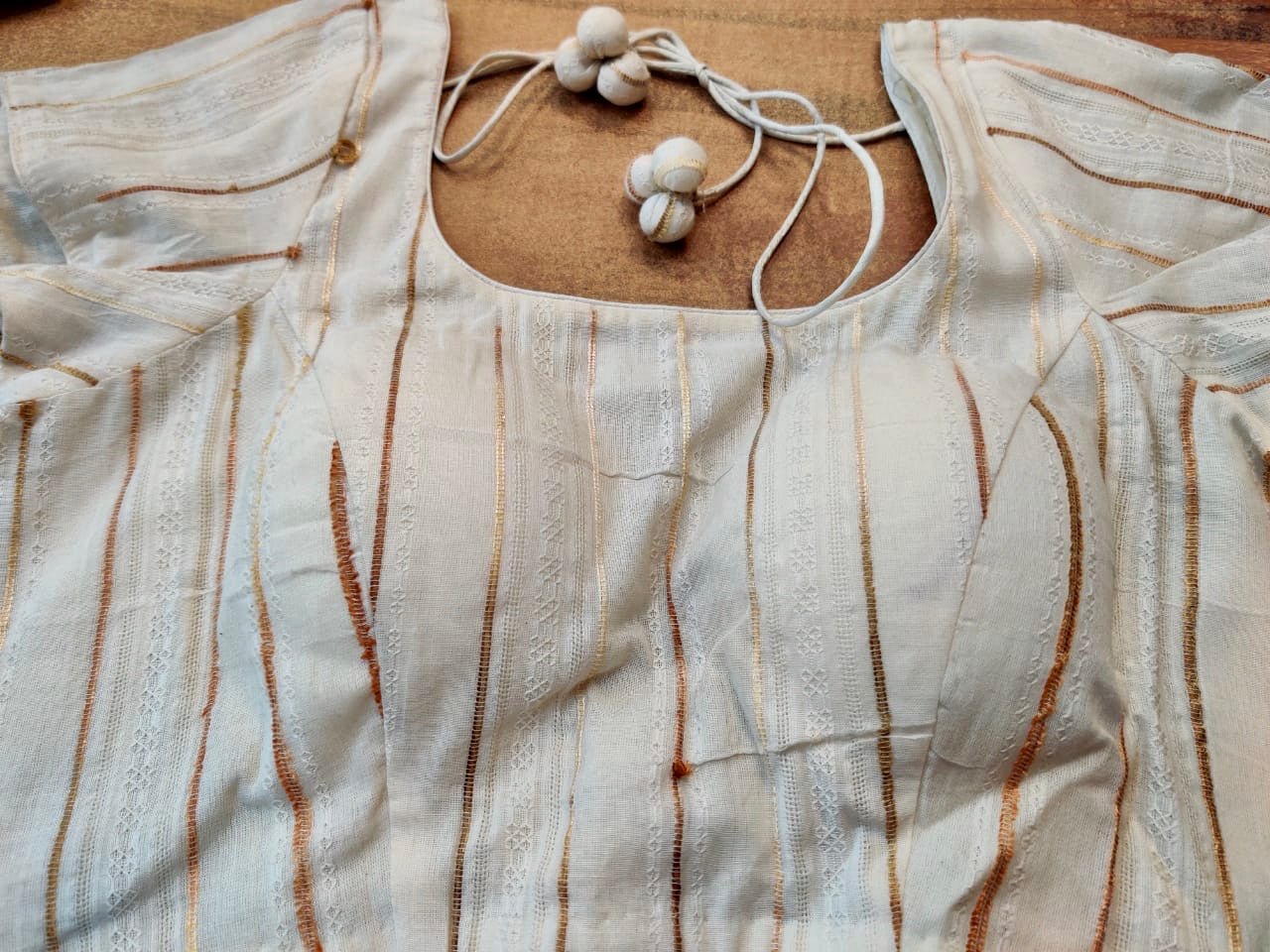 Shop gorgeous cream designer saree blouse online in USA with golden stripes. Elevate your ethnic saree style with a tasteful collection of designer sari blouses, embroidered saree blouses, Banarasi blouse, silk saree blouse from Pure Elegance Indian clothing store in USA.-front