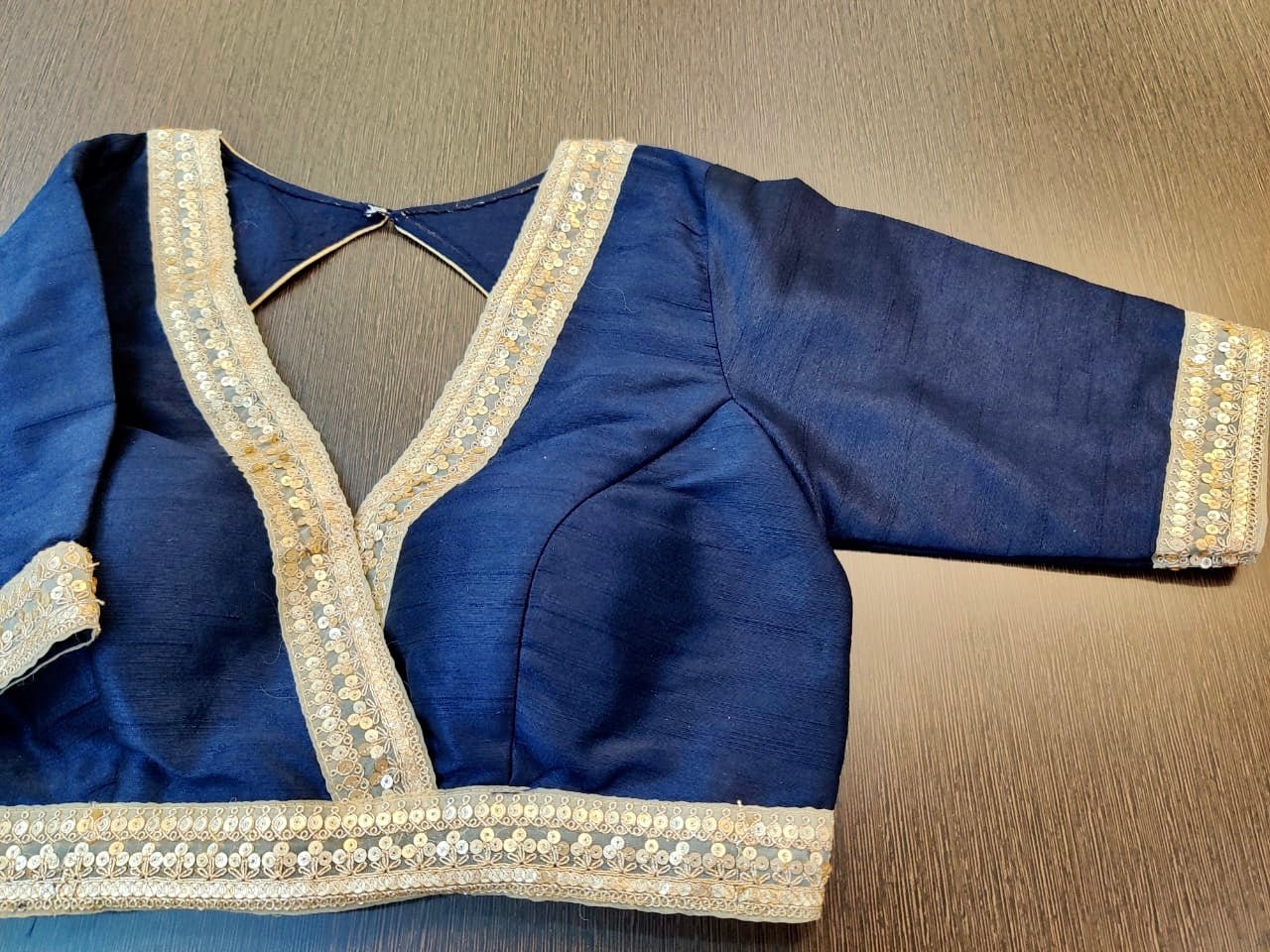 Shop gorgeous navy blue designer sari blouse online in USA with golden embroidered lace. Elevate your ethnic sari style with a stunning collection of designer saree blouses, embroidered saree blouses, Banarasi sari blouse, silk sari blouse from Pure Elegance Indian clothing store in USA.-full view