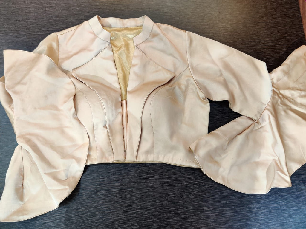 Shop beige designer saree blouse online in USA with ruffle sleeves. Elevate your Indian saree style with exquisite readymade sari blouses, embroidered saree blouses, Benarasi saree blouse, fancy saree blouse from Pure Elegance Indian clothing store in USA.-front