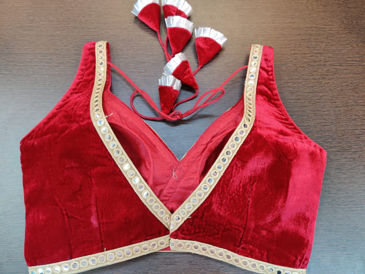 Shop beautiful red sleeveless velvet sari blouse online in USA with mirror work. Elevate your Indian saree style with exquisite readymade sari blouse, embroidered saree blouses, Banarasi sari blouse, designer sari blouse from Pure Elegance Indian clothing store in USA.-back