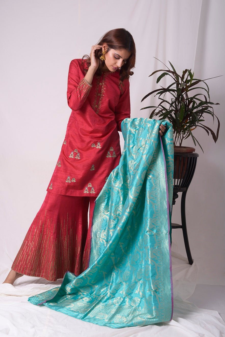 Buy elegant red silk suit online in USA. Suit has gold sequence design work. Kurta has 3/4 length sleeves, high neck, red palazzo and blue dupatta. Simple look makes it elegant.Be the talk of parties and weddings with exquisite designer gowns from Pure Elegance Indian clothing store in USA. Shop online now.-full view-1