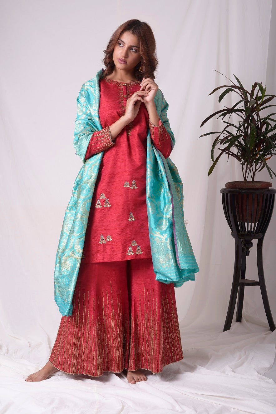 Buy elegant red silk suit online in USA. Suit has gold sequence design work. Kurta has 3/4 length sleeves, high neck, red palazzo and blue dupatta. Simple look makes it elegant.Be the talk of parties and weddings with exquisite designer gowns from Pure Elegance Indian clothing store in USA. Shop online now.-full view-3