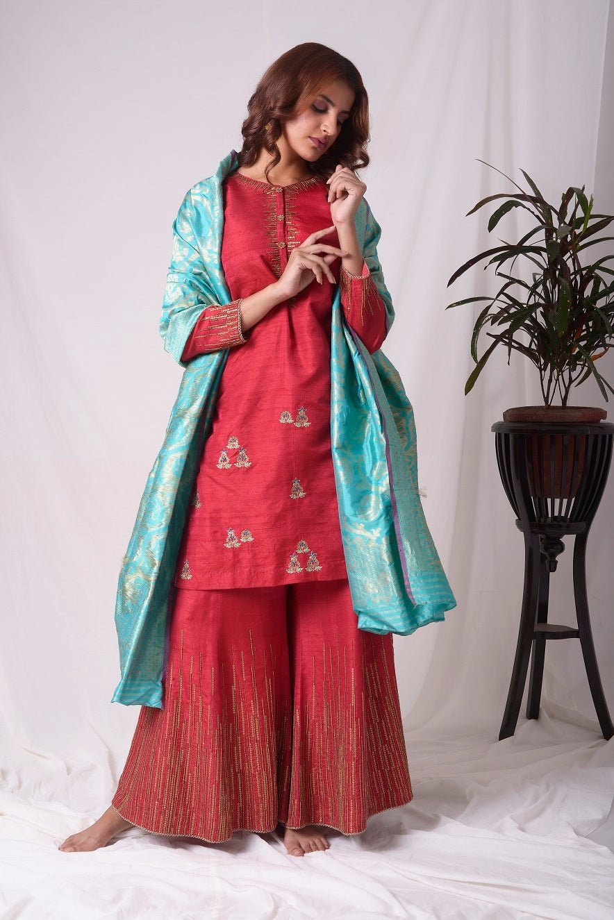 Buy elegant red silk suit online in USA. Suit has gold sequence design work. Kurta has 3/4 length sleeves, high neck, red palazzo and blue dupatta. Simple look makes it elegant.Be the talk of parties and weddings with exquisite designer gowns from Pure Elegance Indian clothing store in USA. Shop online now.-full view-4