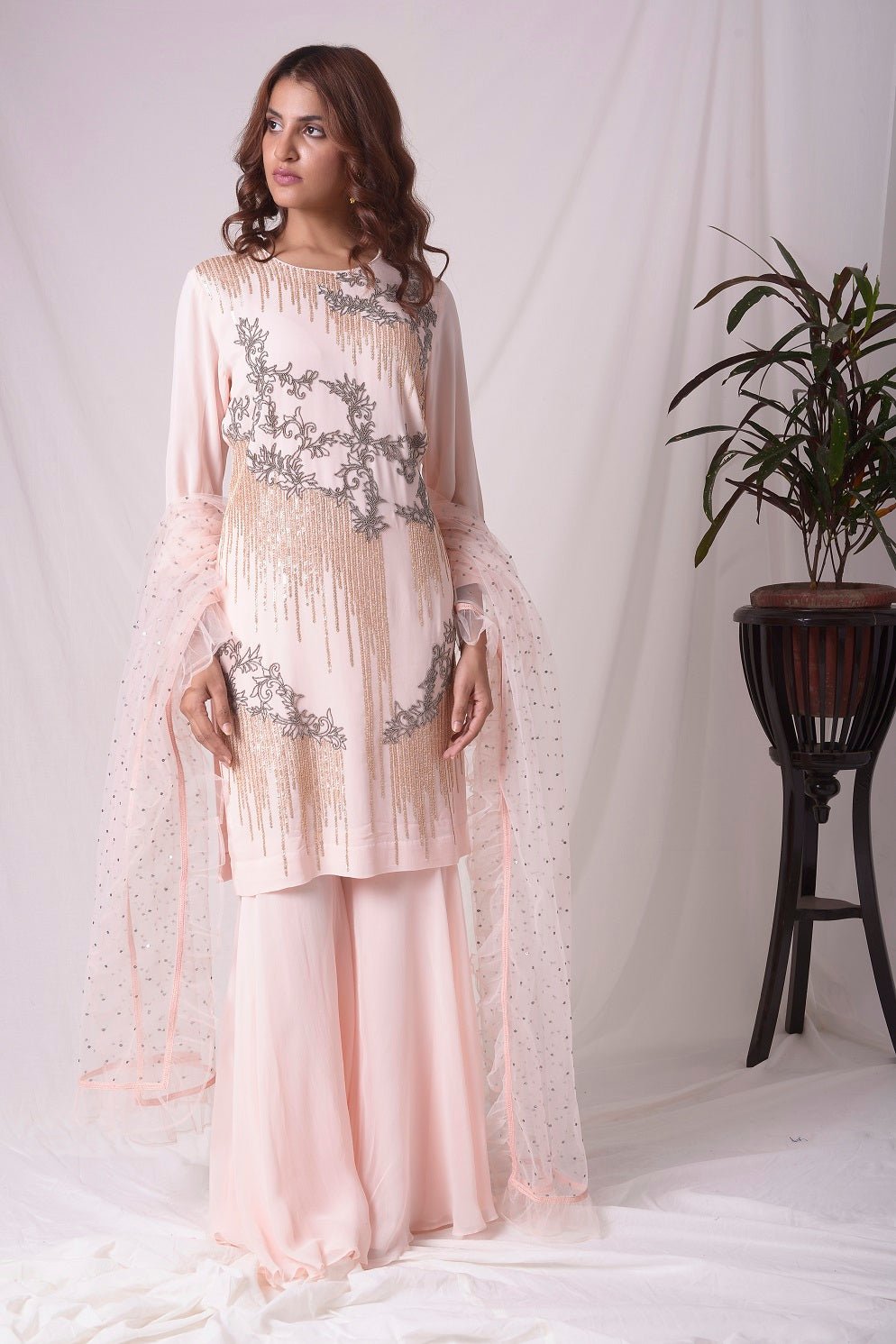 Buy pink georgette suit online in USA. Suit has gold and grey design work. Kurta has long sleeves. Suit had baby pink palazzo and pink net duppatta. Simple look makes it elegant. Be the talk of parties and weddings with exquisite designer gowns from Pure Elegance Indian clothing store in USA. Shop online now.-full view