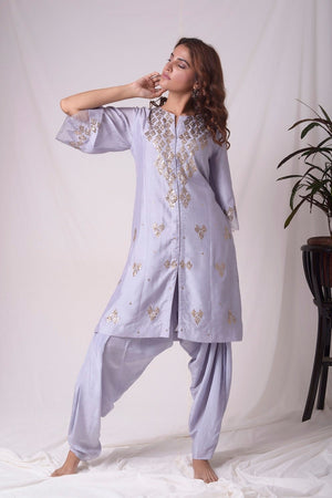 Buy lavender embroidered chanderi suit online in USA. Suit has simple golden work. Kurta has 3/4 length sleeves with net like at border, dhoti and rhombus neckline. Simple look makes it elegant. Be the talk of parties and weddings with exquisite designer gowns from Pure Elegance Indian clothing store in USA. Shop online now.-full view-3