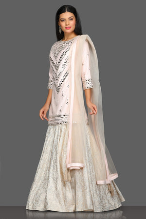 Buy gorgeous powder pink mirror work kurta skirt set online in USA with matching dupatta. Dazzle on weddings and special occasions with exquisite Indian designer dresses, sharara suits, Anarkali suits from Pure Elegance Indian fashion store in USA.-left