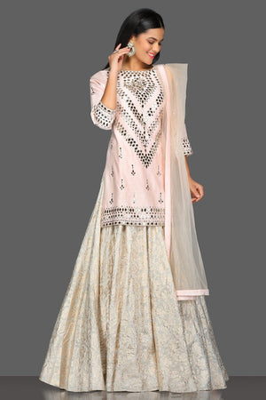 Buy gorgeous powder pink mirror work kurta skirt set online in USA with matching dupatta. Dazzle on weddings and special occasions with exquisite Indian designer dresses, sharara suits, Anarkali suits from Pure Elegance Indian fashion store in USA.-front