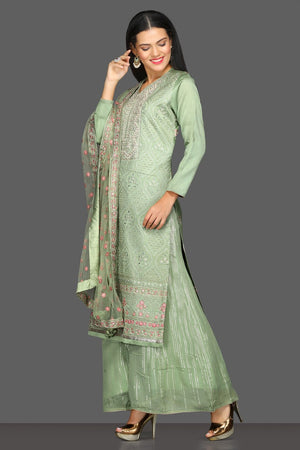 Buy beautiful pista green embroidered suit online in USA with palazzo and embroidered dupatta. Dazzle on weddings and special occasions with exquisite Indian designer lehengas, sharara suits, Anarkali suits from Pure Elegance Indian fashion store in USA.-left