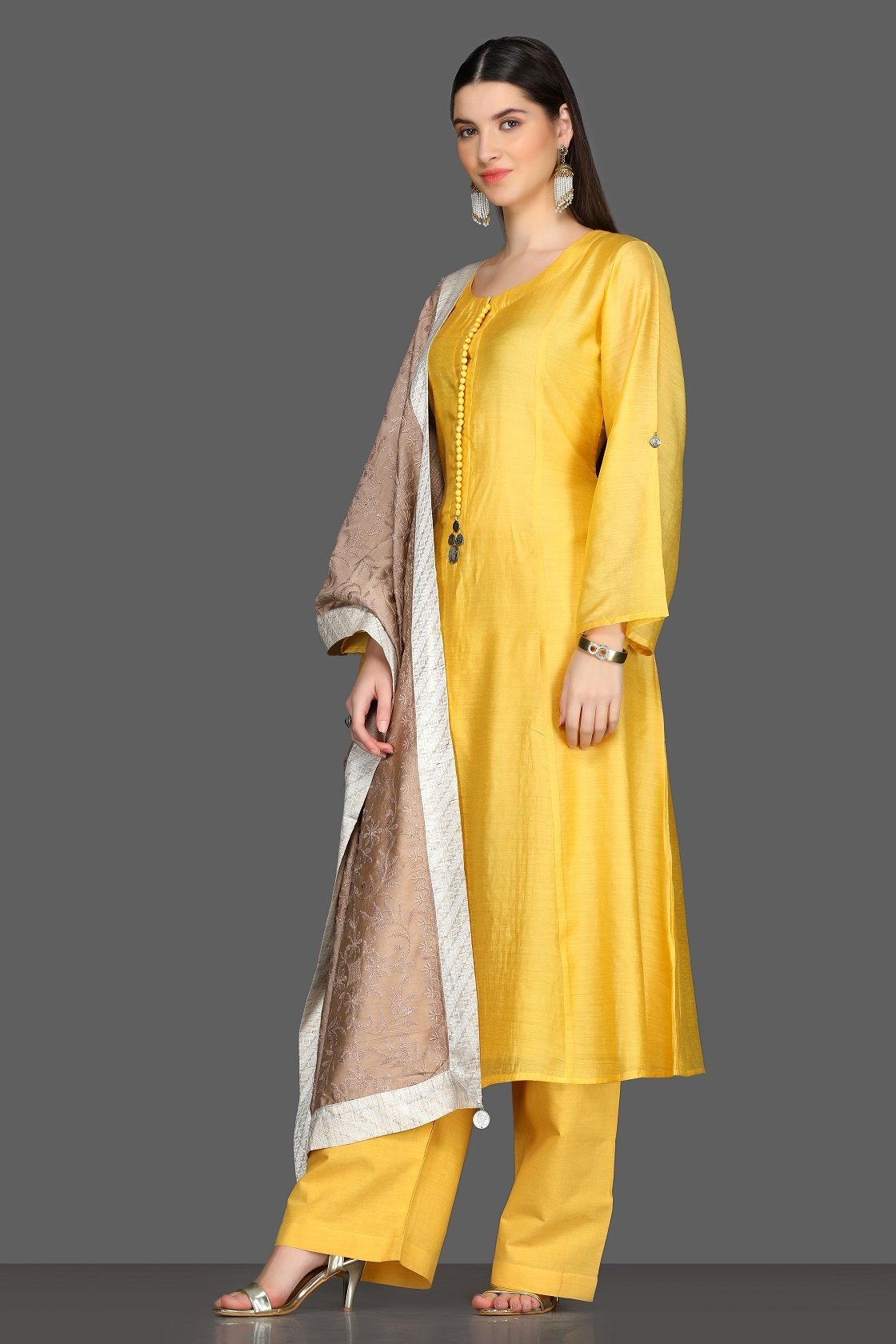Buy elegant solid yellow palazzo suit online in USA with beige dupatta. Dazzle on weddings and special occasions with exquisite Indian designer dresses, sharara suits, Anarkali suits from Pure Elegance Indian fashion store in USA.-left
