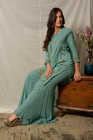 Shop elegant dark aqua embroidered georgette sharara suit online in USA with dupatta. Shine at weddings and special occasions with beautiful Indian designer suits, gowns, lehengas from Pure Elegance Indian clothing store in USA.-sitting