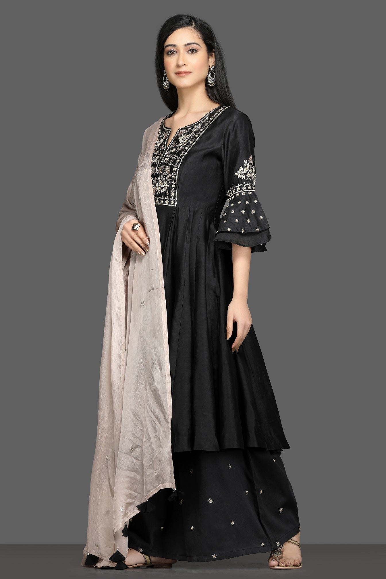 Buy elegant black embroidered flared palazzo suit online in USA with dusty pink dupatta. Dazzle on weddings and special occasions with exquisite Indian designer dresses, sharara suits, Anarkali suits, bridal lehegas from Pure Elegance Indian fashion store in USA.-left side