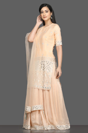 Shop elegant peach embroidered lehenga online in USA with dupatta. Dazzle on weddings and special occasions with exquisite Indian designer dresses, sharara suits, Anarkali suits, bridal lehengas from Pure Elegance Indian fashion store in USA.-left