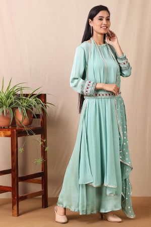 Shop this gorgeous bamberg satin embroidered dress in teel blue color with georgette dupatta featuring a beautiful neckline , belt and cuffs with cutdana and ruby, emerald colored stones, thread embroidery work and dupatta. This beautiful satin material outfit showcases beautiful sleeves with sequin embroidery work and stone work on it and dupatta. Style this set with a pair of diamond earrings and solid pumps to finish the look from Pure Elegance Indian clothing store in USA online now.-Side view.
