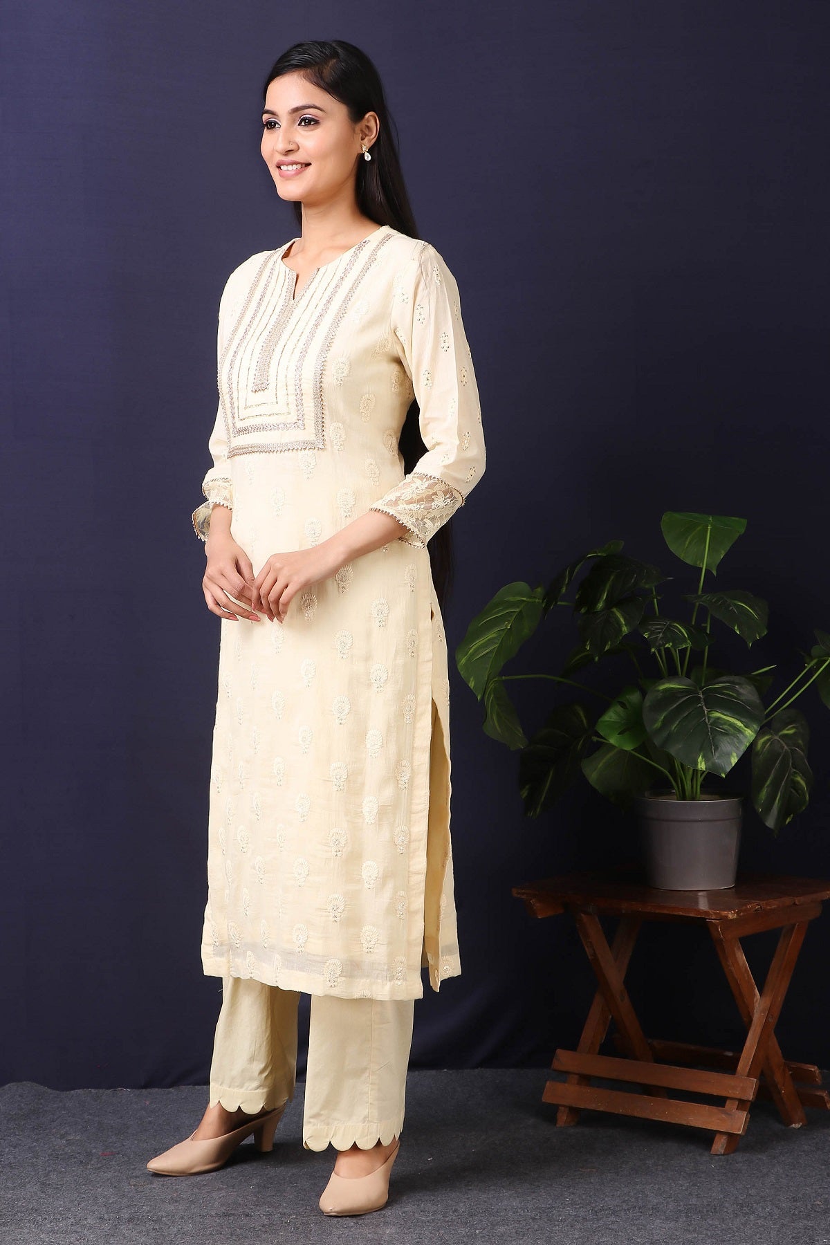 Shop this this gorgeous  mulmul cotton kurta in cream color with cotton stretch pants with sequin and thread embroidery work with gota detailing on neckline. This beautiful mulmul cotton material outfit showcases beautiful sleeves with lace work on it. Style this set of kurta with a pair of diamond earrings and solid pumps to finish the look from Pure Elegance Indian fashion store in USA online now.-Side view.
