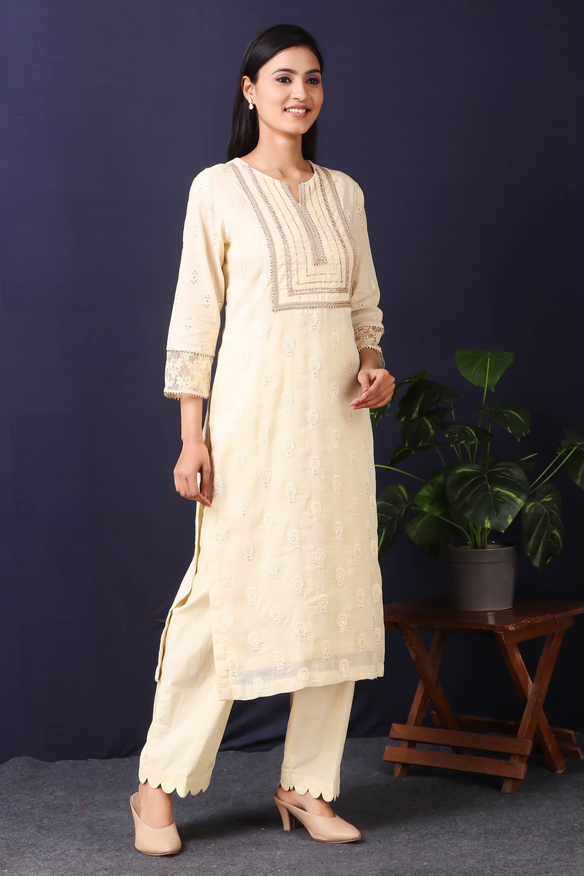 Shop this this gorgeous  mulmul cotton kurta in cream color with cotton stretch pants with sequin and thread embroidery work with gota detailing on neckline. This beautiful mulmul cotton material outfit showcases beautiful sleeves with lace work on it. Style this set of kurta with a pair of diamond earrings and solid pumps to finish the look from Pure Elegance Indian fashion store in USA online now.-Side view.