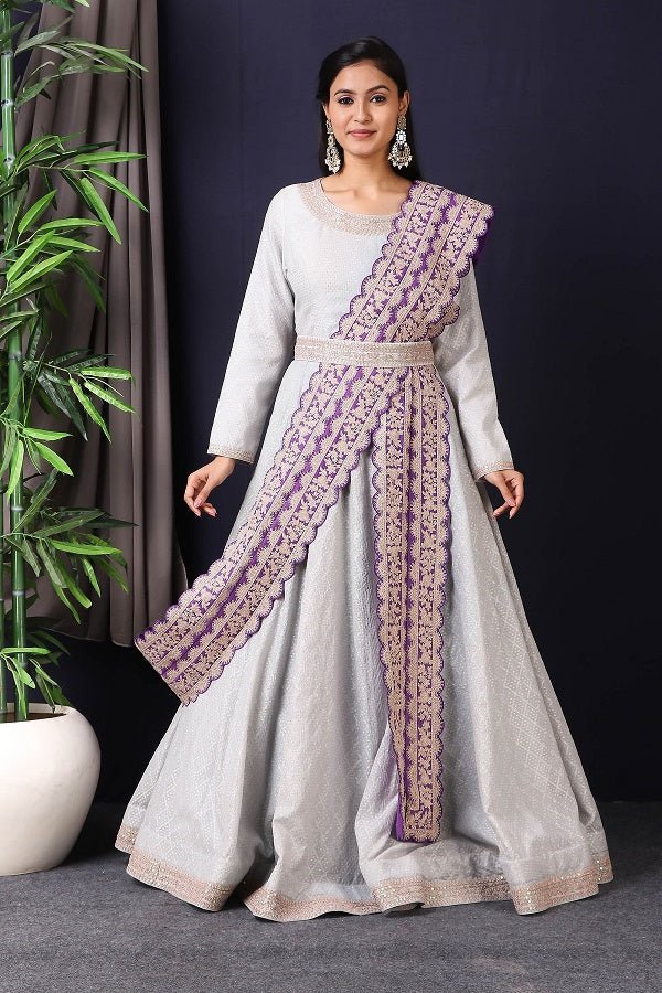 Shop this designer Indo western Anarkali in grey and purple color. This anarkali comes in chanderi silk fabric which has zari dori work around neck and maharani belt with embroidery work. The borders of this anarkali have an exquisite design that is eye-catchy and has lace work on it. Buy designer anarkali attire from Pure Elegance Indian saree store in USA.-Full view.
