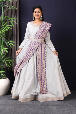 Shop this designer Indo western Anarkali in grey and purple color. This anarkali comes in chanderi silk fabric which has zari dori work around neck and maharani belt with embroidery work. The borders of this anarkali have an exquisite design that is eye-catchy and has lace work on it. Buy designer anarkali attire from Pure Elegance Indian saree store in USA.-Full view.