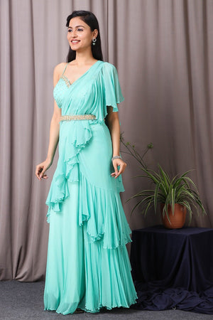 Shop this designer indo western Saree in aqua blue colour. This saree comes in chiffon and upadda silk fabric. The borders of the saree have an exquisite design that is eye-catchy and has sequin and thread embroidery work on it. Complete the look with embroidered blouse showcasing floral and animal motifs especially around the neckline and on the backside. Shop this designer from Pure Elegance Online Indian store now.-Side view.