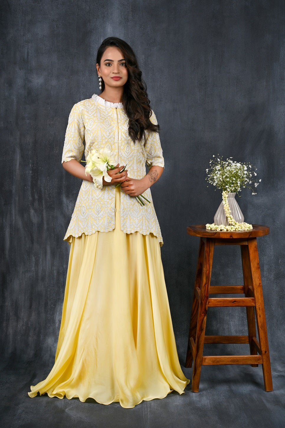 Buy this designer satin organza lehenga. This asymmetrical layered piece in lemon&white is embellished with a fully embroidered blouse and mesmerizing dori work. A fully embroidery satin blouse makes this a sophisticated piece of luxury that will captivate you in its calmness and serenity. Style this set with a pair of diamond earrings and solid pumps to finish the look from Pure Elegance Indian clothing store in USA online now.-Full view.