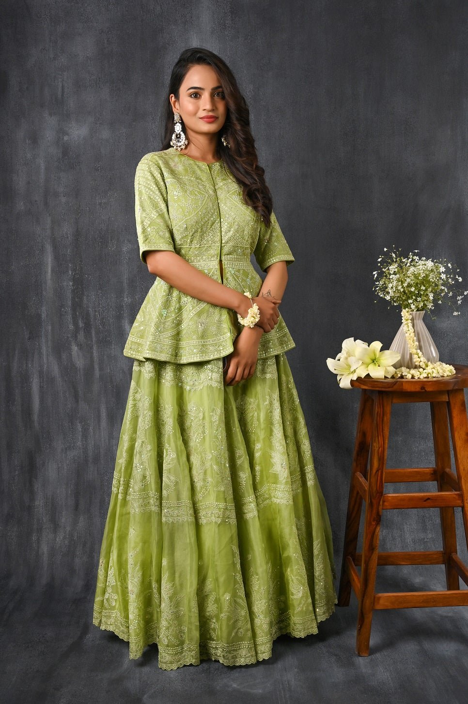 Buy this pista green pure silk organza peplum lehenga from Pure Elegance featuring intricate  tonal thread embroidery and slight shimmer work. Made with premium quality pure silk organza fabric, this set contains a choli, a lehenga. Pair it up with statement jewellery to complete your lookbook this season. Style this set with a pair of diamond earrings and solid pumps to finish the look from Pure Elegance  Indian clothing store in USA online now.-Full view.