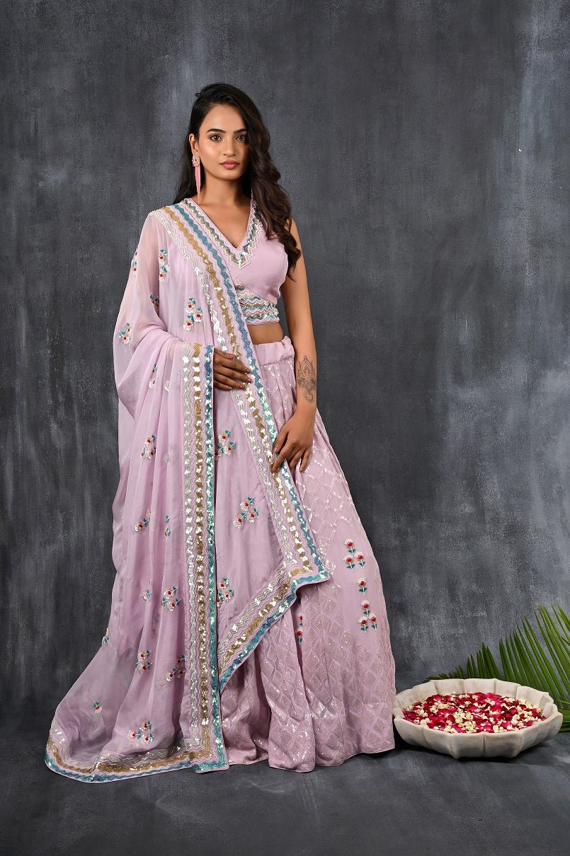 Buy this lilac georgette embroidered lehenga with designer blouse from Pure Elegance with multicolour sequence and tonal sequin embroidery work. Made with premium quality georgette and tabby silk fabric, this set contains a designer blouse, a lehenga and dupatta. Pair it up with statement jewellery to complete your lookbook this season. Style this set with a pair of diamond earrings and solid pumps to finish the look from Pure Elegance Indian clothing store in USA online now.-Full view.