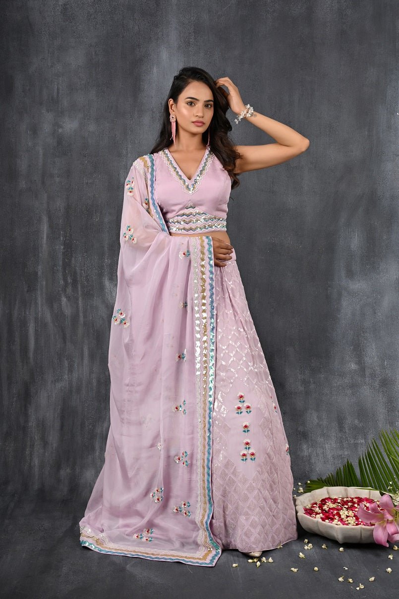 Buy this lilac georgette embroidered lehenga with designer blouse from Pure Elegance with multicolour sequence and tonal sequin embroidery work. Made with premium quality georgette and tabby silk fabric, this set contains a designer blouse, a lehenga and dupatta. Pair it up with statement jewellery to complete your lookbook this season. Style this set with a pair of diamond earrings and solid pumps to finish the look from Pure Elegance Indian clothing store in USA online now.-Full view.