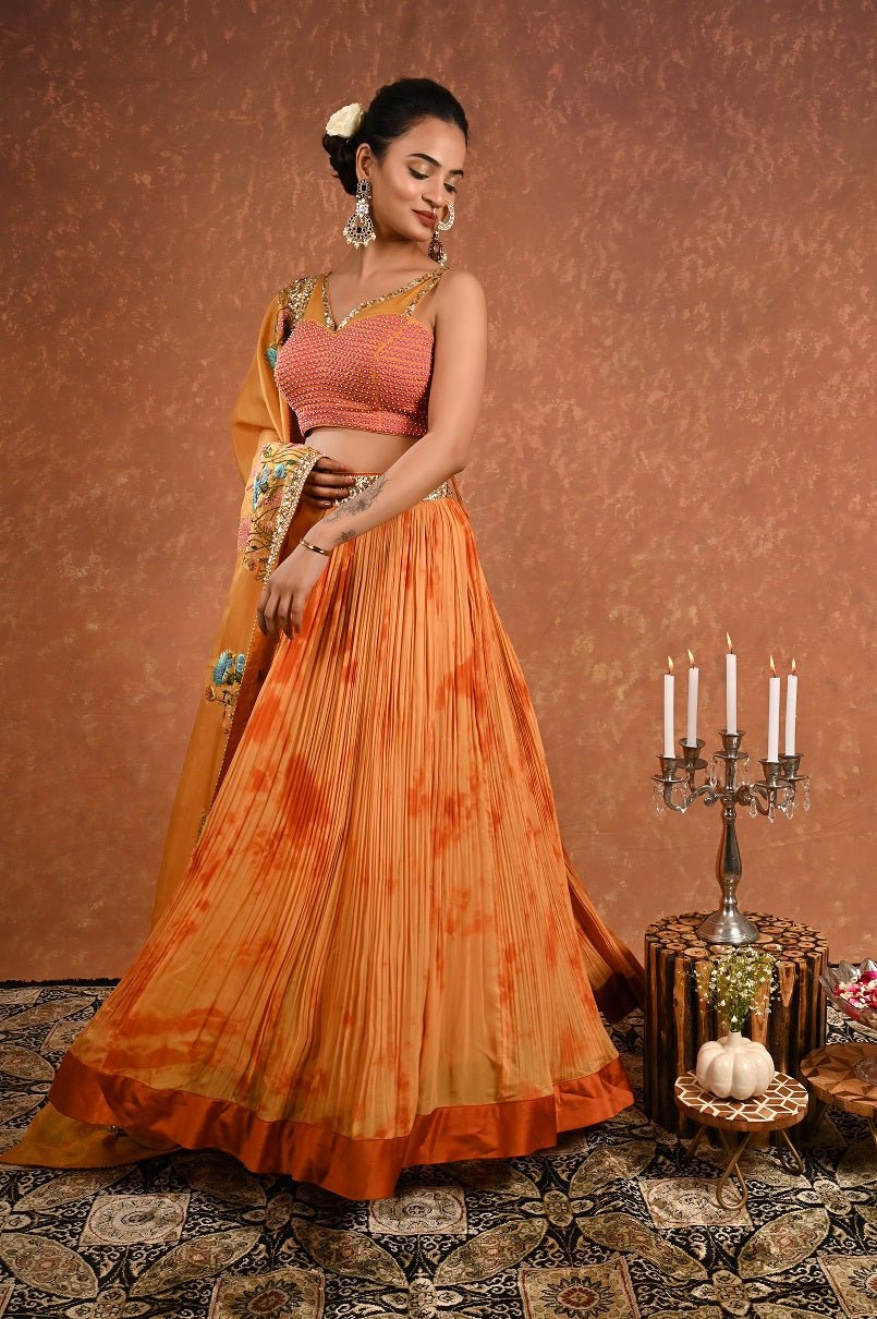 Shop this gorgeous safrron lehenga choli from Pure Elegance featuring intricate embroidery and a V-neck. Made with premium quality georgette and silk fabric, this set contains a choli, a lehenga, and a dupatta. Pair it up with statement jewellery to complete your lookbook this season Style this set with a pair of diamond earrings and solid pumps to finish the look from Pure Elegance Indian clothing store in USA online now.-Side view.