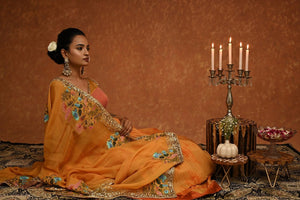 Shop this gorgeous safrron lehenga choli from Pure Elegance featuring intricate embroidery and a V-neck. Made with premium quality georgette and silk fabric, this set contains a choli, a lehenga, and a dupatta. Pair it up with statement jewellery to complete your lookbook this season Style this set with a pair of diamond earrings and solid pumps to finish the look from Pure Elegance Indian clothing store in USA online now.-Close up.
