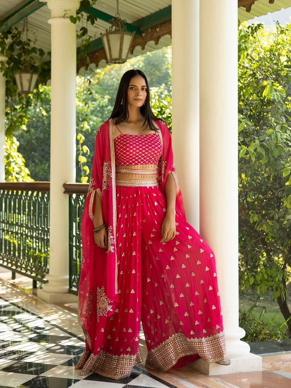 Buy beautiful fuschia pink embroidered palazzo crop top online in USA with cape. Dazzle on weddings and special occasions with exquisite Indian designer dresses, sharara suits, Anarkali suits, wedding lehengas from Pure Elegance Indian fashion store in USA.-front