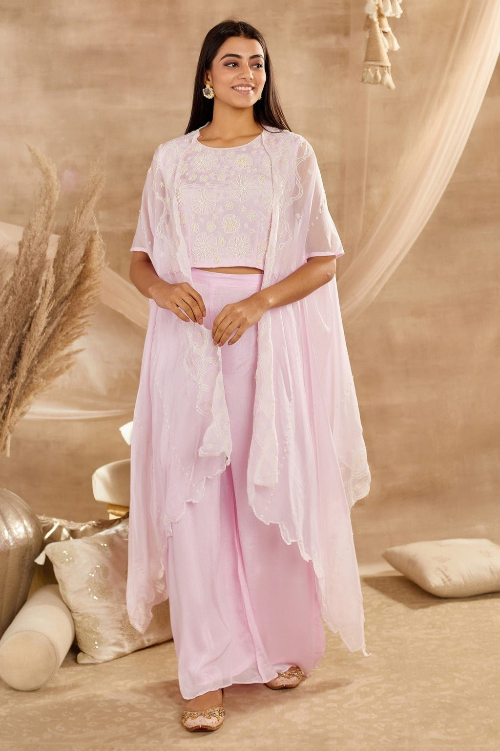 Shop powder pink embroidered crop top palazzo online in USA with cape. Dazzle on weddings and special occasions with exquisite Indian designer dresses, sharara suits, Anarkali suits, wedding lehengas from Pure Elegance Indian fashion store in USA.-full view
