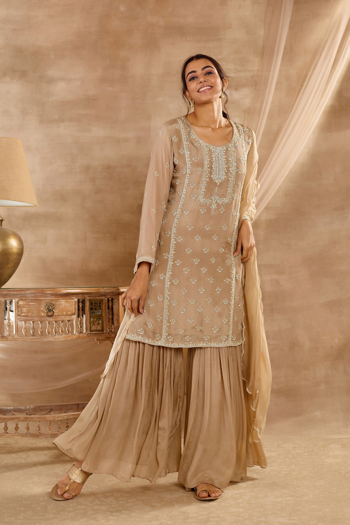 Buy stunning beige embroidered sharara suit online in USA with dupatta. Dazzle on weddings and special occasions with exquisite Indian designer dresses, palazzo suits, Anarkali suits, wedding lehengas from Pure Elegance Indian fashion store in USA.-front