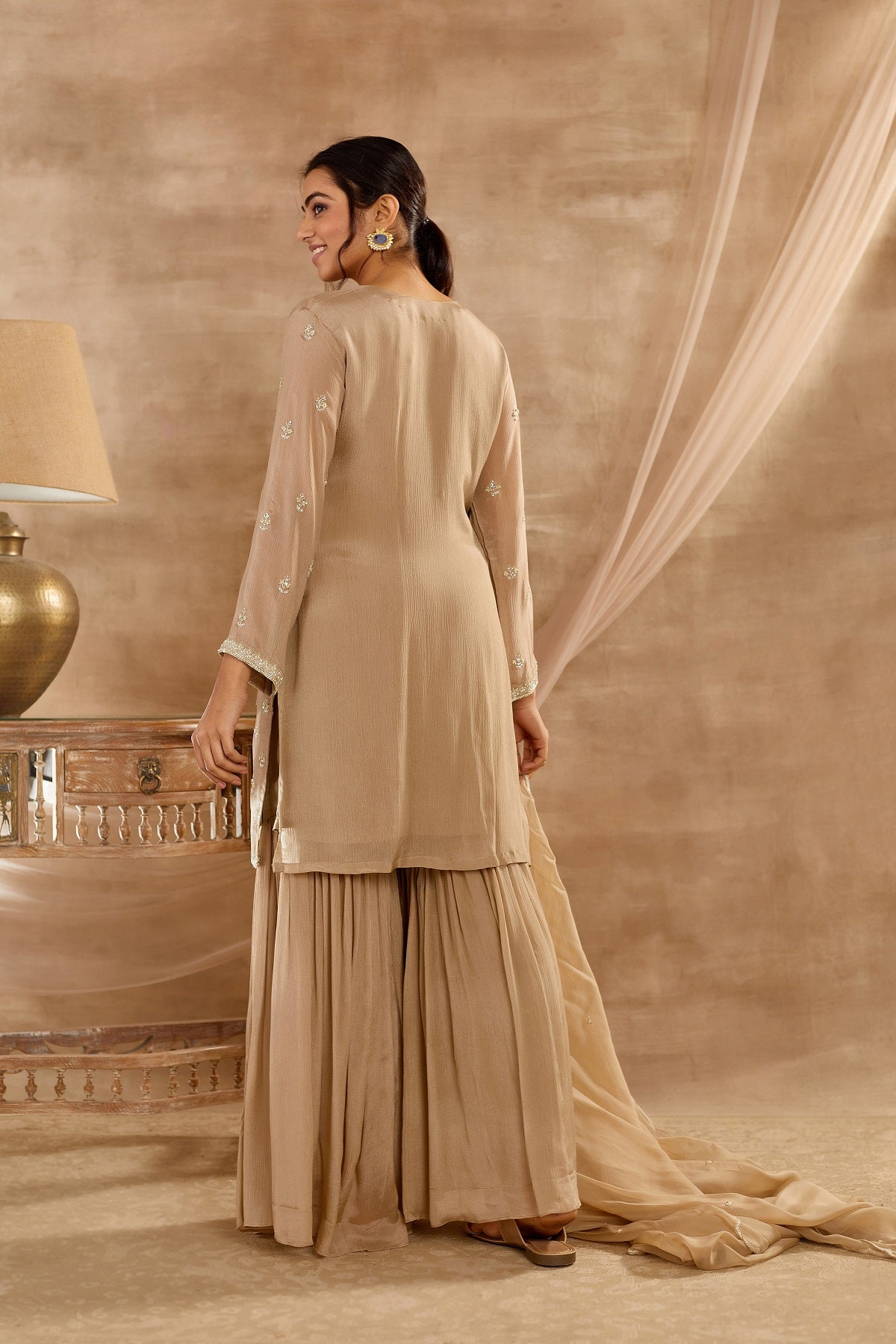 Buy stunning beige embroidered sharara suit online in USA with dupatta. Dazzle on weddings and special occasions with exquisite Indian designer dresses, palazzo suits, Anarkali suits, wedding lehengas from Pure Elegance Indian fashion store in USA.-back