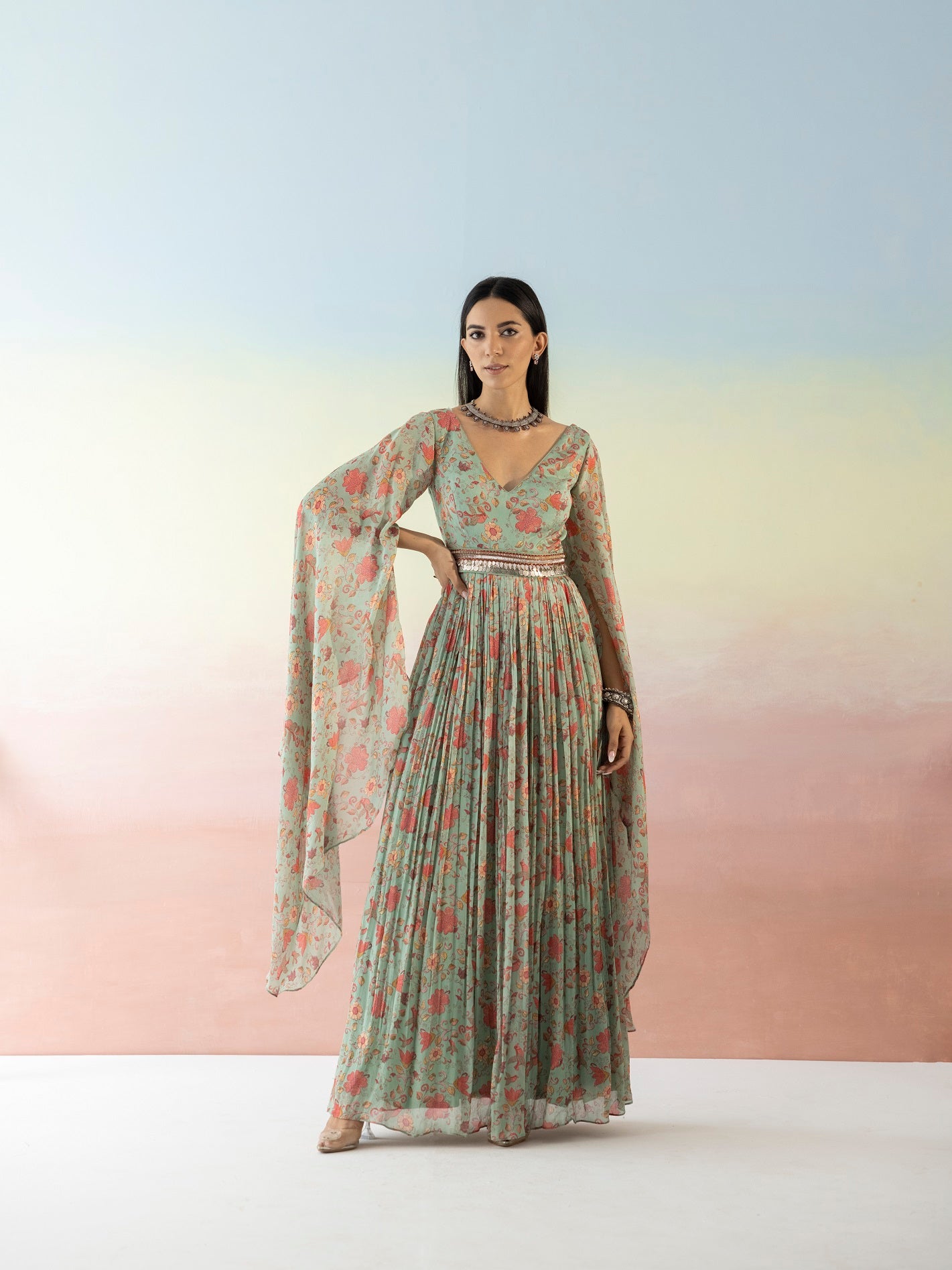 Buy beautiful green floral cape sleeves dress online in USA with embroidered belt. Make a fashion statement on festive occasions and weddings with designer suits, Indian dresses, Anarkali suits, palazzo suits, designer gowns, sharara suits from Pure Elegance Indian fashion store in USA.-front