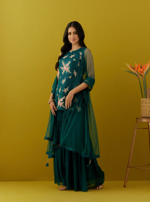 Shop stunning teal embroidered sharara suit online in USA with dupatta. Dazzle on weddings and special occasions with exquisite Indian designer dresses, sharara suits, Anarkali suits, bridal lehengas, sharara suits from Pure Elegance Indian clothing store in USA.-side