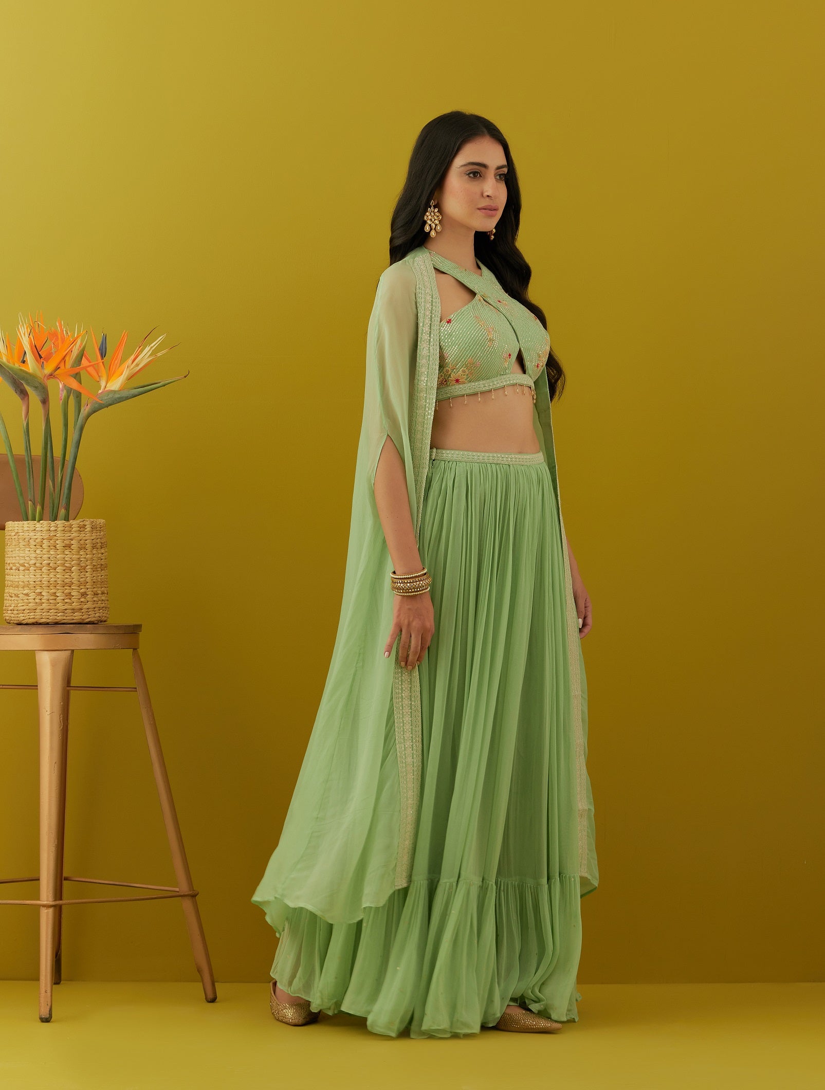 Shop green embroidered bustier online in USA with sharara and cape. Dazzle on weddings and special occasions with exquisite Indian designer dresses, sharara suits, Anarkali suits, bridal lehengas, sharara suits from Pure Elegance Indian clothing store in USA.-side
