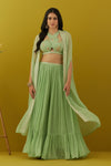 Shop green embroidered bustier online in USA with sharara and cape. Dazzle on weddings and special occasions with exquisite Indian designer dresses, sharara suits, Anarkali suits, bridal lehengas, sharara suits from Pure Elegance Indian clothing store in USA.-front