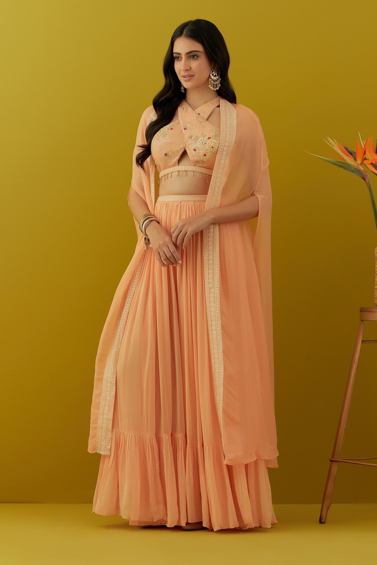 Buy beautiful peach embroidered bustier online in USA with sharara and cape. Dazzle on weddings and special occasions with exquisite Indian designer dresses, sharara suits, Anarkali suits, bridal lehengas, sharara suits from Pure Elegance Indian clothing store in USA.-full view