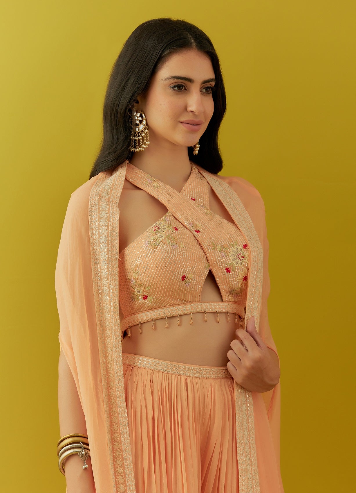 Buy beautiful peach embroidered bustier online in USA with sharara and cape. Dazzle on weddings and special occasions with exquisite Indian designer dresses, sharara suits, Anarkali suits, bridal lehengas, sharara suits from Pure Elegance Indian clothing store in USA.-closeup