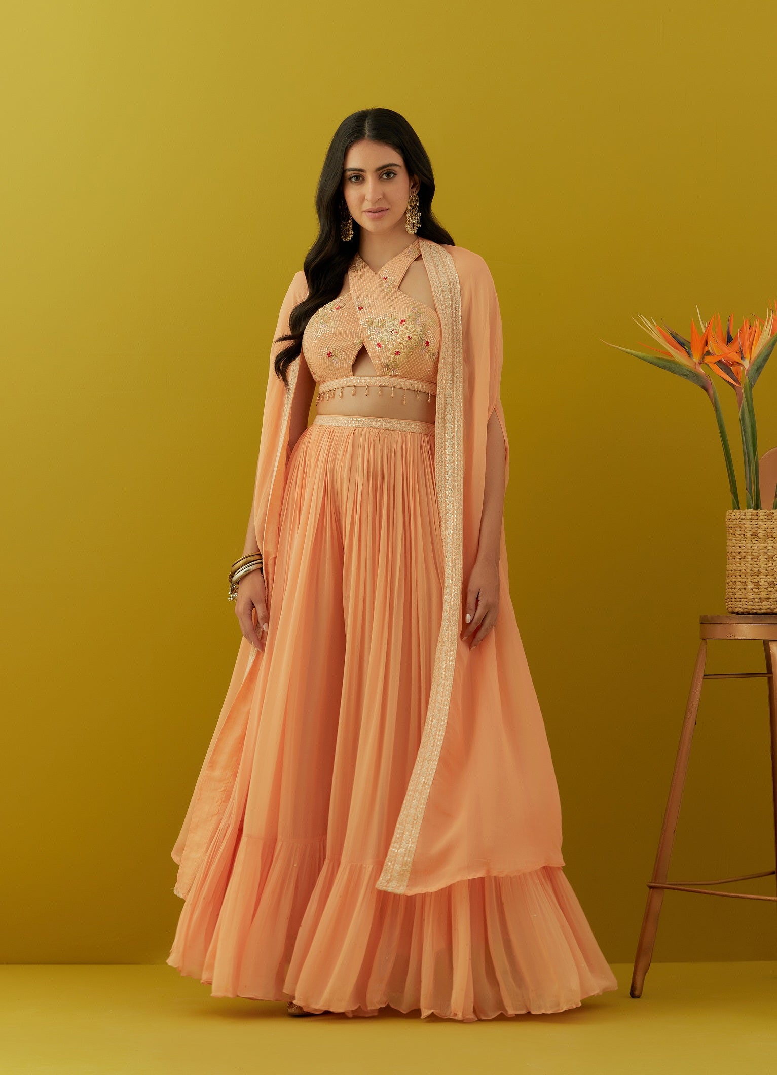 Buy beautiful peach embroidered bustier online in USA with sharara and cape. Dazzle on weddings and special occasions with exquisite Indian designer dresses, sharara suits, Anarkali suits, bridal lehengas, sharara suits from Pure Elegance Indian clothing store in USA.-front