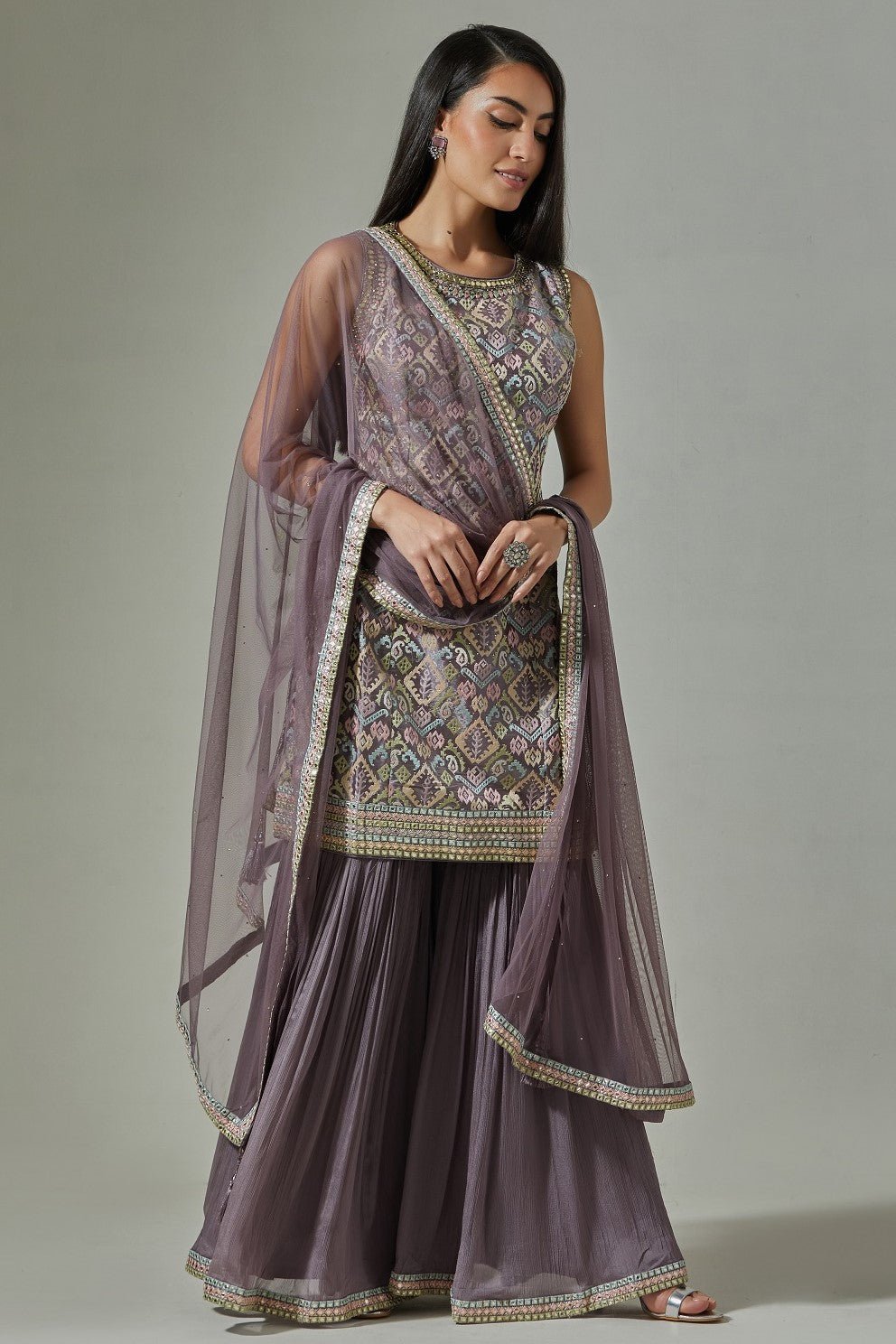 Buy stunning lilac hand embroidered jacquard sharara suit online in USA with net dupatta. Dazzle on weddings and special occasions with exquisite Indian designer dresses, sharara suits, Anarkali suits, wedding lehengas from Pure Elegance Indian fashion store in USA.-front
