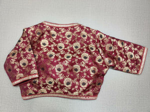 Buy this maroon and gold-colored brocade is woven design padded saree blouse that has a round neck, short sleeves, front opening with hook, and eye closure. Pair this fashionable blouse with a beautiful solid sari and statement neckpiece and you are good to go! Buy this designer blouse in the USA from Pure Elegance. -Back View