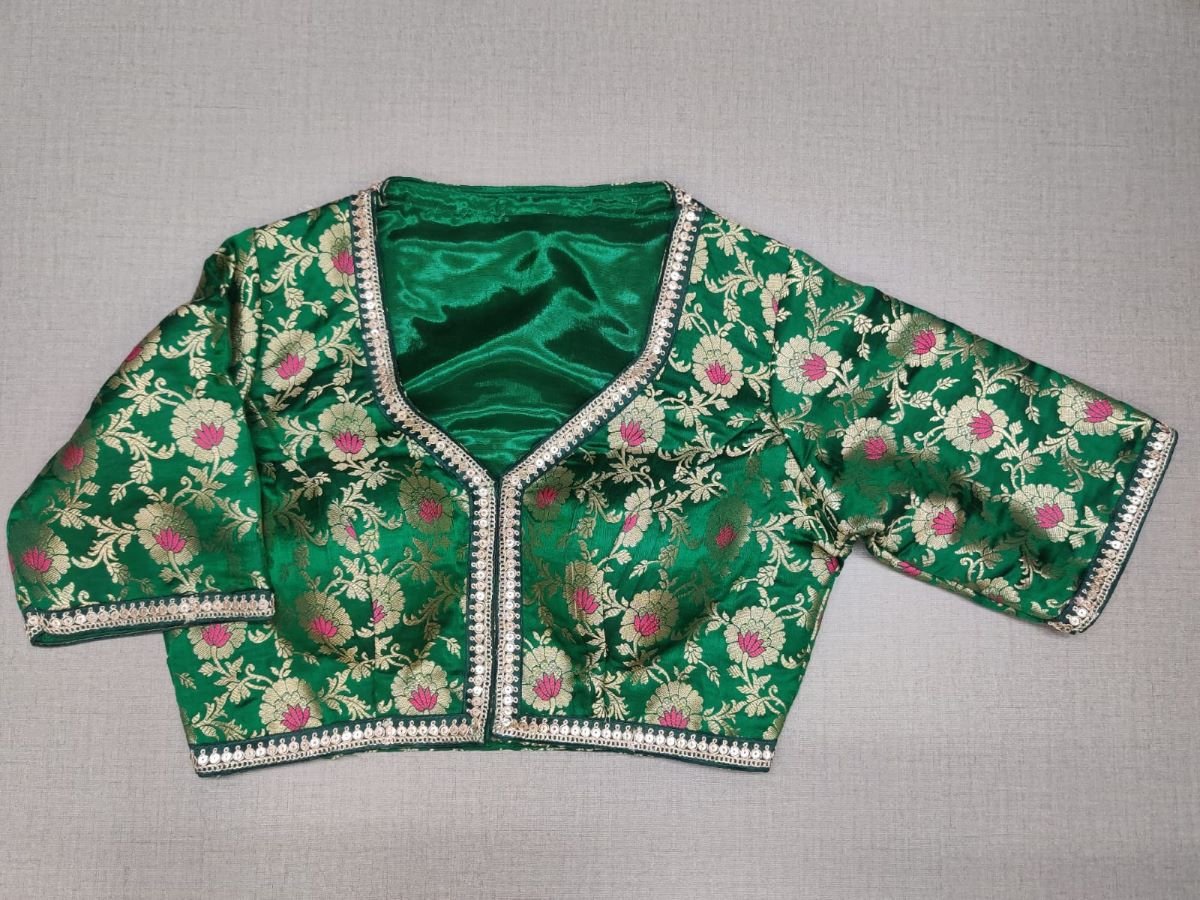 Buy a beautiful green color Indian saree designer blouse with golden embroidery work. You can pair up with any Indian Saree for any occasion to make your look elegant. Green and gold-colored brocade is a woven design padded saree blouse that has a round neck, short sleeves, front opening with hook, and eye closure. You can pair it with any Indian Saree, Banarasi Silk Sarees, and Chanderi Silk sarees. Buy it from Pure Elegance sari blouse from Pure Elegance Indian clothing store in USA.- Front View