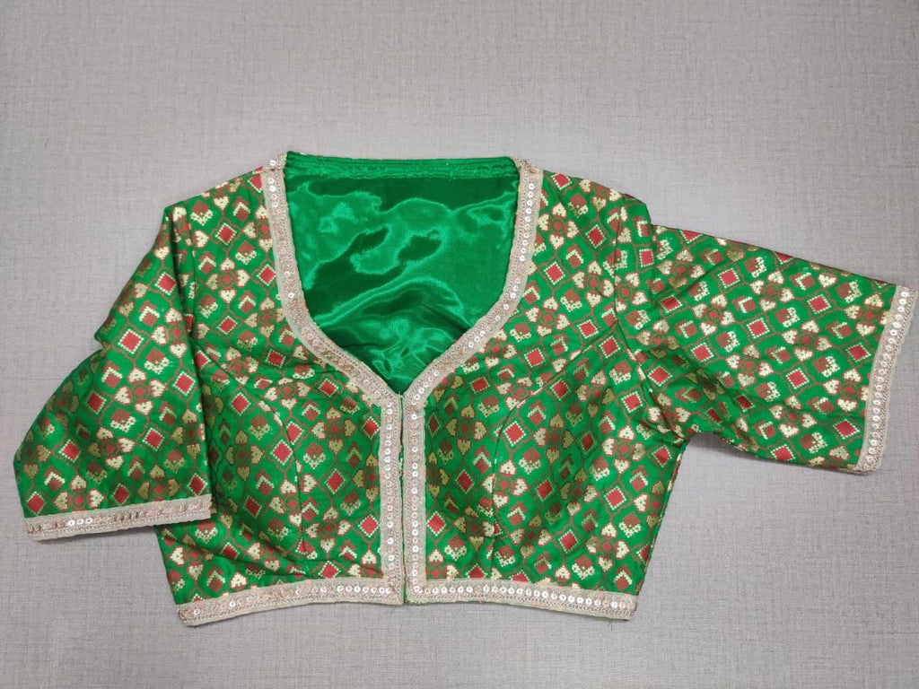 Buy this exquisite green color with a red golden design. This blouse is great to buy. Pair this fashionable blouse with beautiful silk sarees and a statement neckpiece and you're good to go!  Elevate your Indian saree style with exquisite readymade sari blouse, embroidered saree blouses, Banarasi sari blouse, and designer sari blouse from Pure Elegance Indian clothing store in USA.- Front View