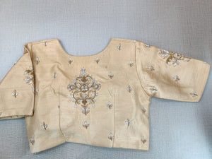 Buy a beige blouse crafted in hammered silk. Tailored with three-fourth sleeves, the blouse features a smocked embroidered front and back for comfort and style and a zip closure. Give your ethnic look a dazzling update with this grey silk blouse. Elevate your Indian saree style with exquisite readymade sari blouse, embroidered saree blouses, Banarasi sari blouse, and designer sari blouse from Pure Elegance Indian clothing store in the USA.- Back View