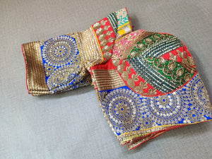 Buy a Multi-Color blouse crafted in hammered silk with beautiful embroidery work. Tailored with short sleeves, the blouse features a smocked back for comfort and style, and a tie-up closure. Give your ethnic look a dazzling update with this multi-color blouse. Buy this designer blouse in the USA from Pure Elegance. - Folded view