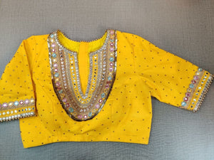 Buy a blouse dipped into a palette of pastels and adorned with glimmering details, this yellow blouse indulges the wearer in the sweet charm of summer. Tailored in mesh and designed with a beautiful embroidery style on the neck and sleeves. Buy this designer blouse in the USA from Pure Elegance. - front View